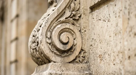 Gros plan sur une moulure architecturale en pierre de taille parisienne avec détails sculptés d'époque