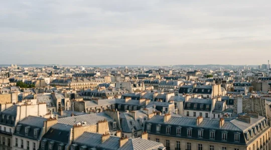 Vue aérienne des toits haussmanniens parisiens illustrant la densité urbaine et le marché immobilier de la capitale